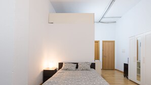 A bedroom with a bed, a nightstand, a wardrobe, and a door. - Rafaela Guest House (Málaga)