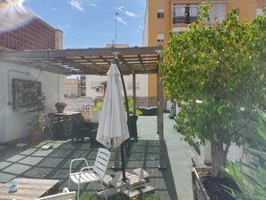A patio area with a pergola, outdoor furniture, and potted plants. - Rafaela Guest House (Málaga)