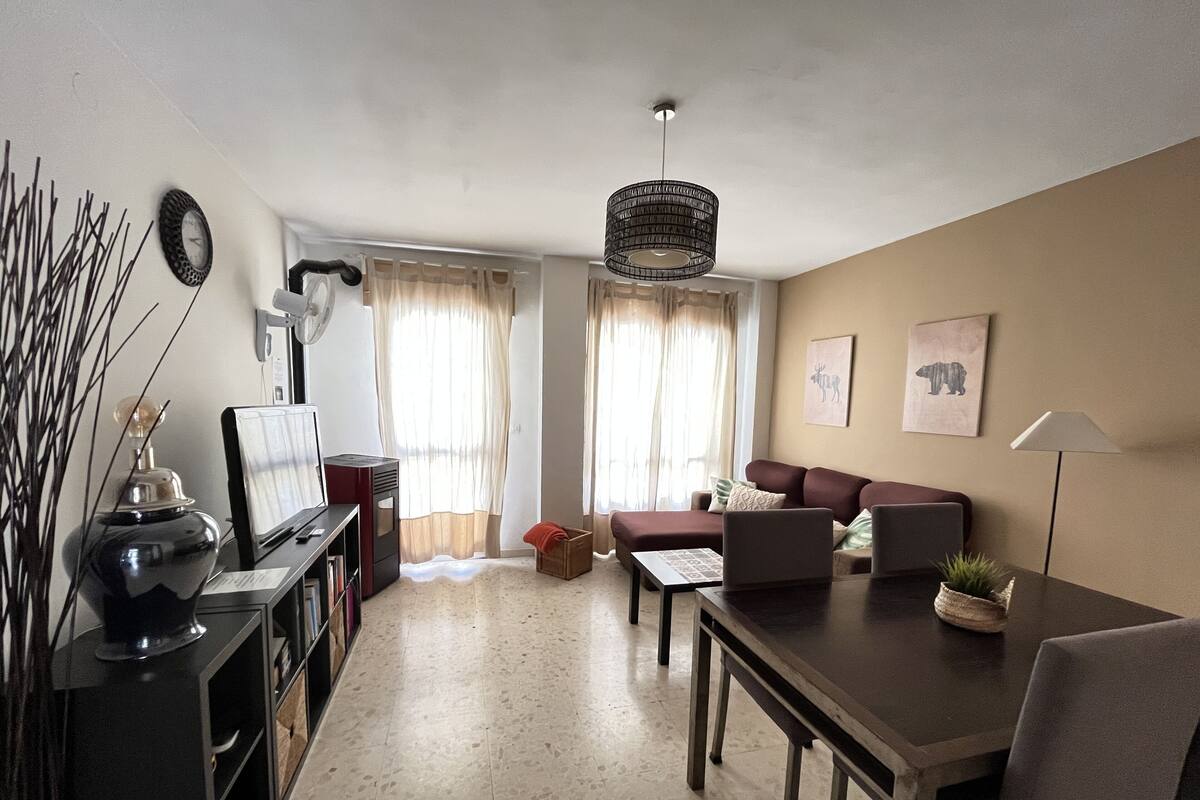 A living room with a sofa, a coffee table, a TV, and a lamp.