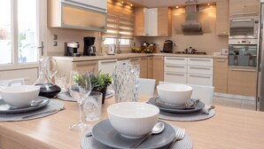 A modern kitchen with a dining area set for four. - Villa Stergos (Rhodes)