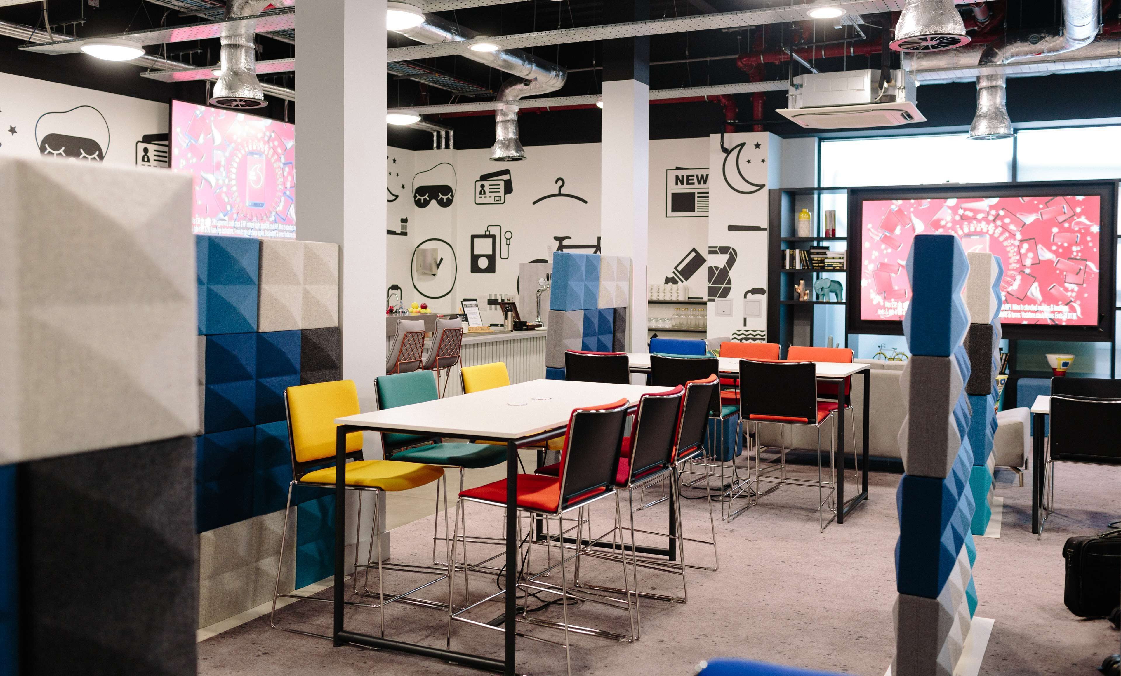 A modern, well-lit cafe with colorful seating and a variety of wall decorations.