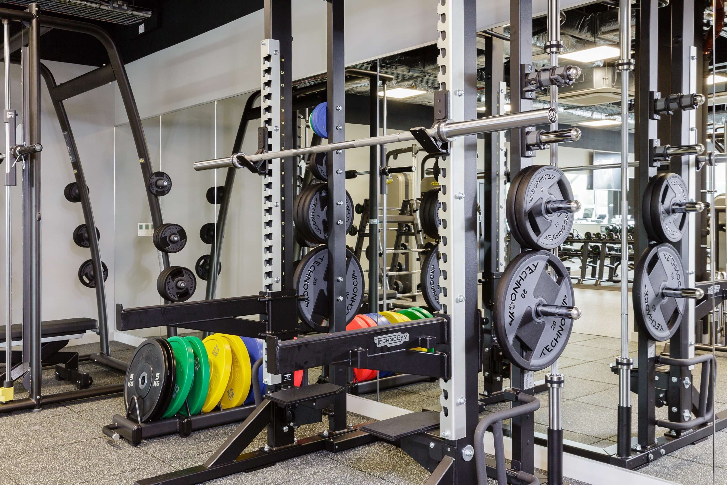 Ett gym med utrustning för styrketräning, inklusive skivstänger och viktskivor.