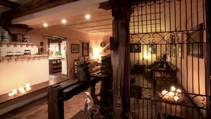 Un interior acogedor con vigas de madera, una zona de comedor y vistas a través de un ventanal con barrotes.