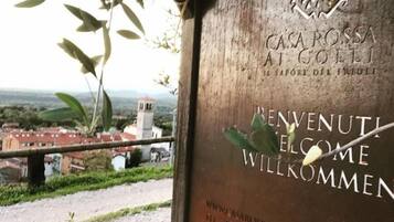 A sign with the text "CASA ROSSA AT GOLLI" and "REVENUTI EL GOME WILKOMMEN" indicating a welcoming message.
