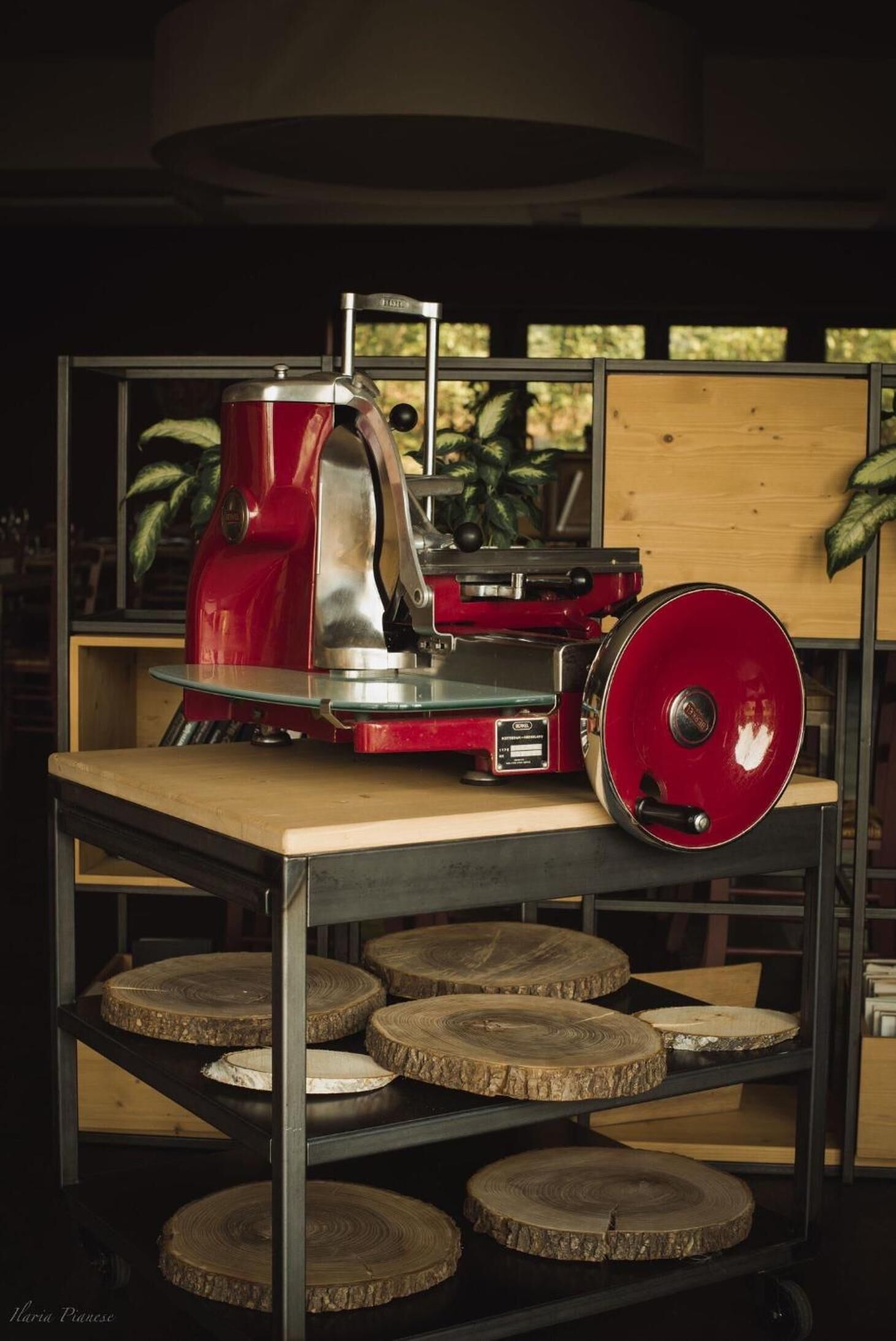 A red wood splitter on a table with wooden planks below.