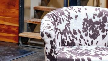 A chair with a spotted pattern, a wooden staircase, and a metal railing.