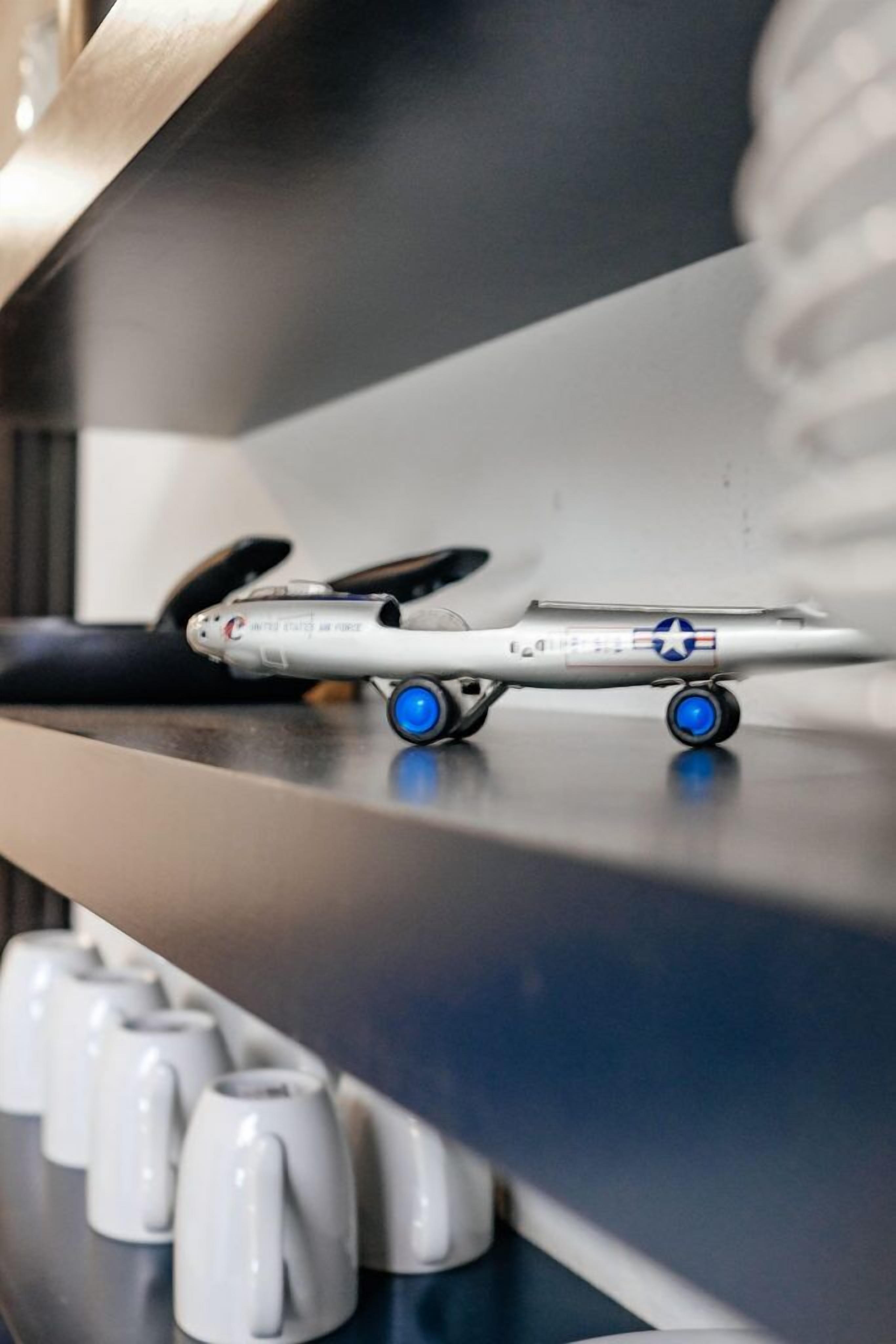 Un modelo de avión con ruedas azules sobre una estantería.