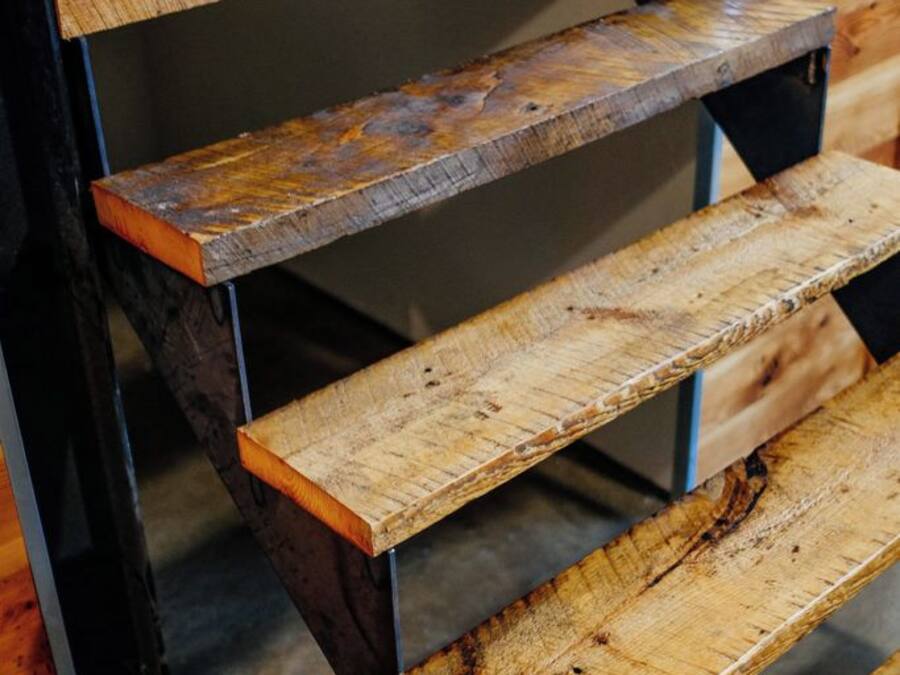 Een aantal houten traptreden met metalen leuningen.