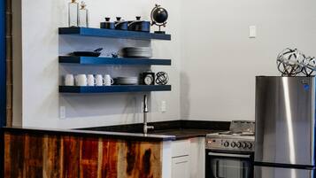 Una cocina con encimera de madera, estufa, horno y refrigerador de acero inoxidable.