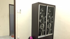 Une pièce comprenant une armoire, une porte, une poubelle et une prise de courant.