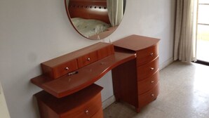 A bedroom with a wooden dresser, a mirror, and a bed with a headboard. - Wardini (Bhamdoun)