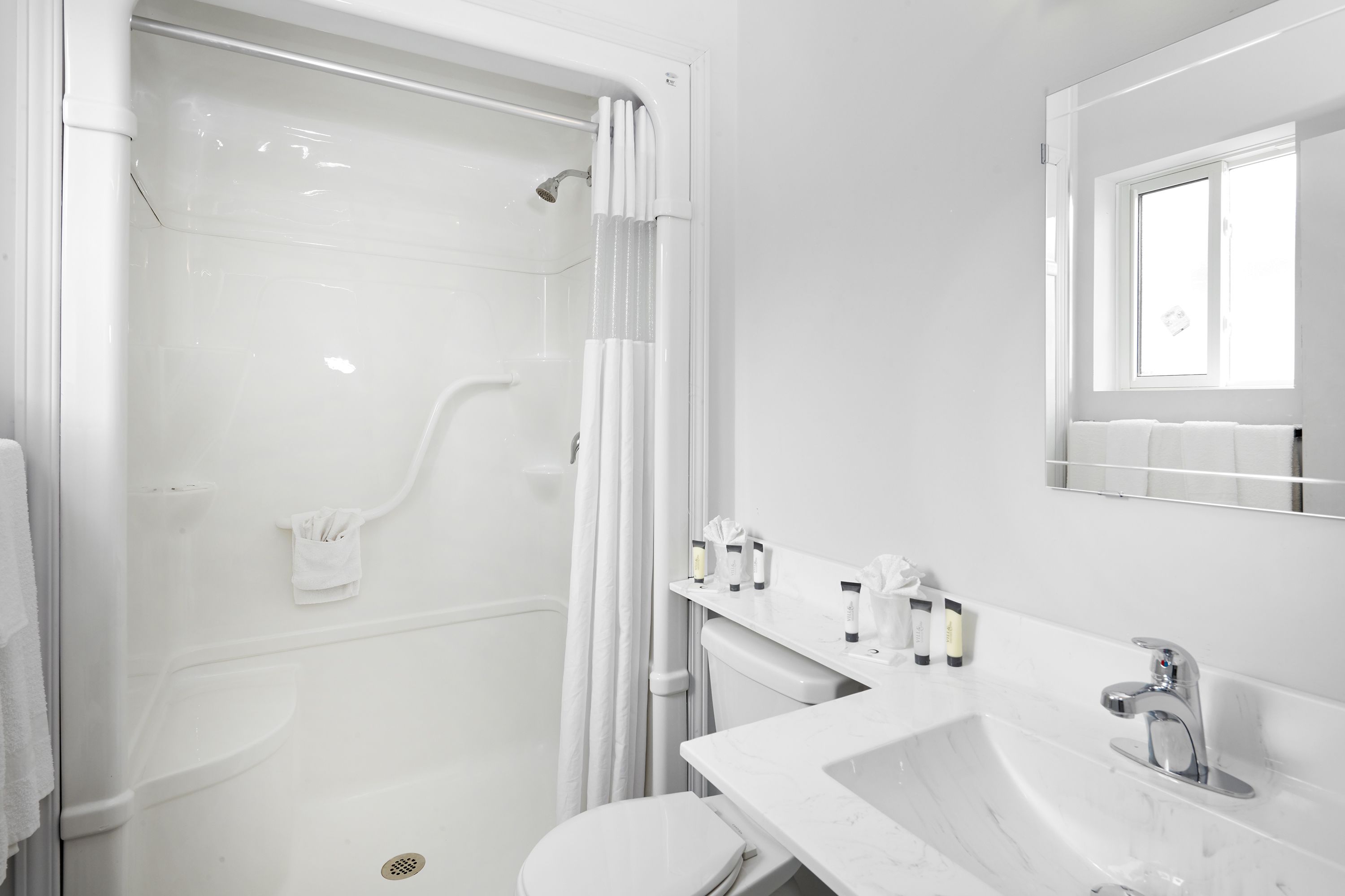 A modern bathroom with a bathtub, toilet, and sink.