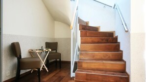 Una escalera de madera con barandilla de metal que conduce a un piso superior.