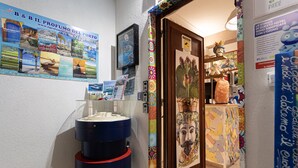 Un baño con lavabo, espejo y un cartel con la imagen de un rostro en la pared.