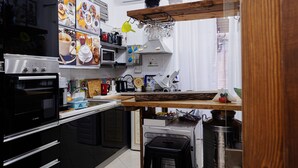 Una cocina moderna con electrodomésticos de acero inoxidable, encimera de madera y diversos utensilios de cocina.