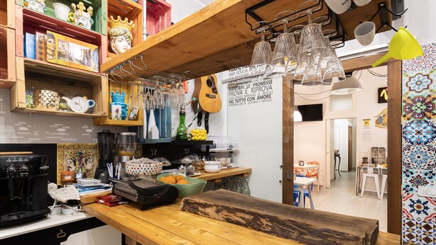 Una cocina con estantes de madera, una máquina de café y diversos utensilios de cocina.