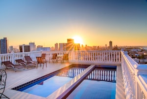 Una piscina al aire libre, sillones reclinables de piscina