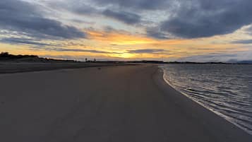 Una playa cerca, sillas reclinables de playa, toallas de playa