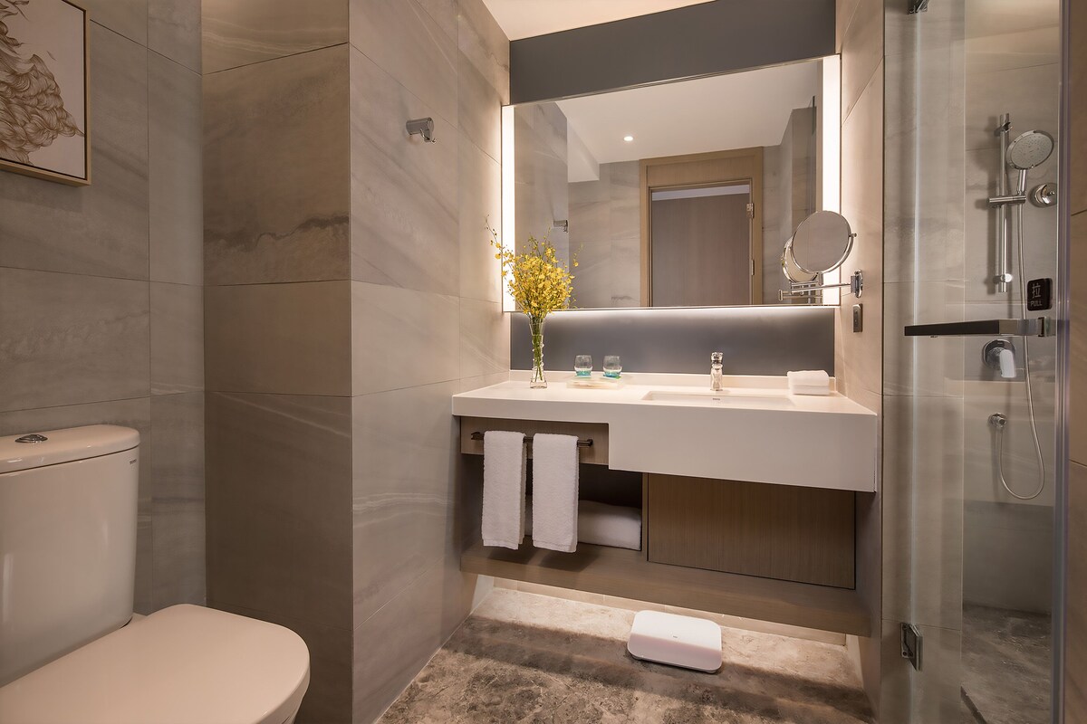 A modern bathroom with a toilet, sink, and shower.