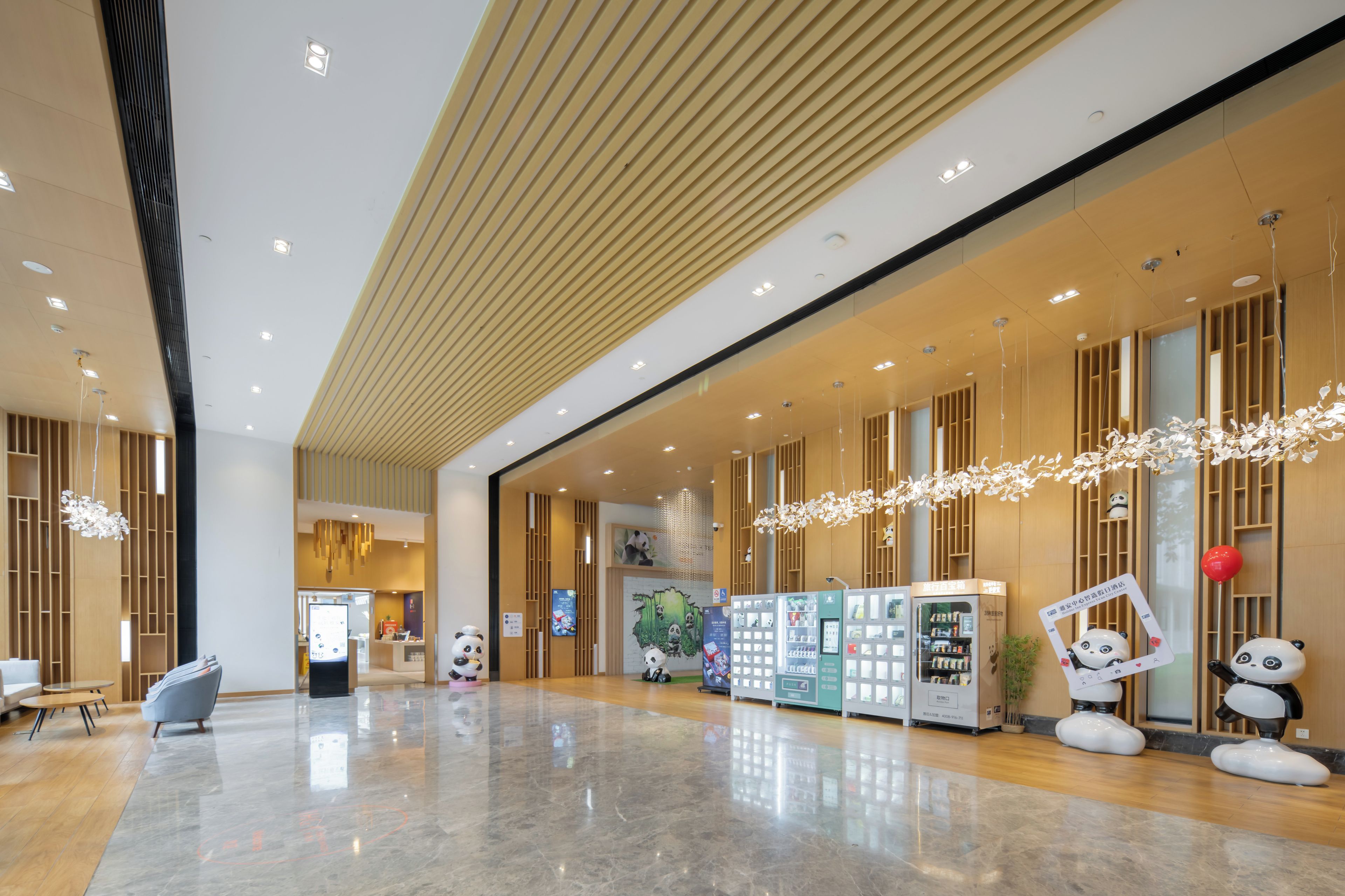 Um hall amplo com design moderno, com máquina de vendas automática, decorações de panda e piso limpo e lustroso.