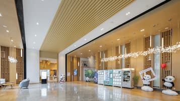 Um hall amplo com design moderno, com máquina de vendas automática, decorações de panda e piso limpo e lustroso.