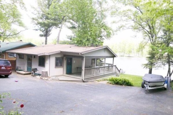 A lakeside cabin with a porch, a covered outdoor grill, and a boat trailer. - Eischen Cottage 2 on Lake Delton (Wisconsin Dells)