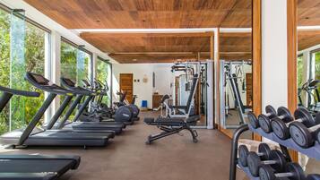 A gym with treadmills, weight machines, and dumbbells.