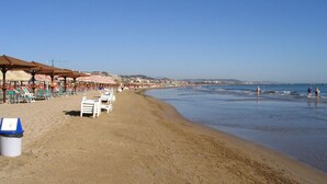 A beach with sun loungers and umbrellas, a clear sky, and a calm sea. - Ofena, Gem in the mountains (Ofena)