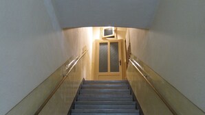 A staircase with handrails, a door at the top, and a light fixture above. - Ofena, Gem in the mountains (Ofena)