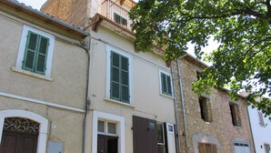 A row of buildings with traditional architecture, featuring wooden doors and shutters, and a street in front. - Ofena, Gem in the mountains (Ofena)
