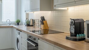 Une cuisine moderne équipée d’un lave-linge, d’un four et d’une machine à café.