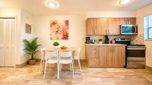 A modern kitchen with wooden cabinets, a stainless steel refrigerator, and a microwave.