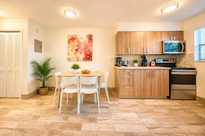 Een moderne keuken met houten kastjes, een roestvrijstalen koelkast en een magnetron.