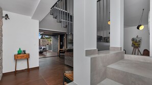 Ein modernes Interieur mit Treppe, Essbereich und Blick ins Freie.