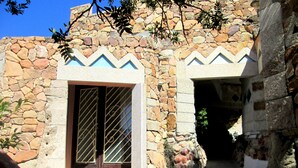 Un edificio de piedra con entrada de tejas y puerta de madera.
