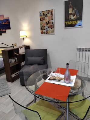 A modern living room with a glass coffee table, a grey sofa, and a bookshelf. - Giripaso Charming Apartment (Firenze)
