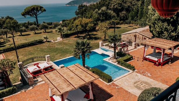 Un espace piscine doté d’une terrasse en bois, de chaises longues et d’une pergola.