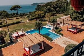 A pool area with a wooden deck, lounge chairs, and a pergola. - Talici Hill - Rustic Villas (Sutomore)