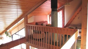 A wooden interior with a loft bed, a fireplace, and a staircase. - WILDERNESS PARK VERCORS BEAUTIFUL HOUSE WITH PANORAMIC VIEWS (Saint-Andéol)