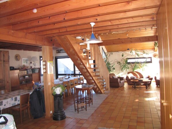 A spacious living area with a wooden staircase, a dining area, and a kitchen. - WILDERNESS PARK VERCORS BEAUTIFUL HOUSE WITH PANORAMIC VIEWS (Saint-Andéol)