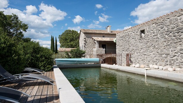 A stone building with a pool, wooden deck, and lounge chairs. - Independent Mas not overlooked with 10700m2 of enclosed park, 14x4 heated pool  (Labeaume)