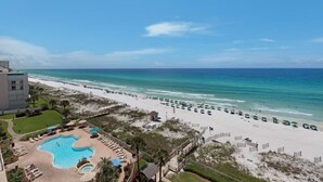 A beach resort with a swimming pool, beach umbrellas, and a view of the ocean. - Sterling Sands - Gulf front - Sleeps 8 - Three Bedroom - 3 Bath (Destin)
