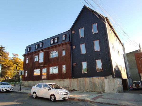 A two-story building with a dark facade and multiple windows.