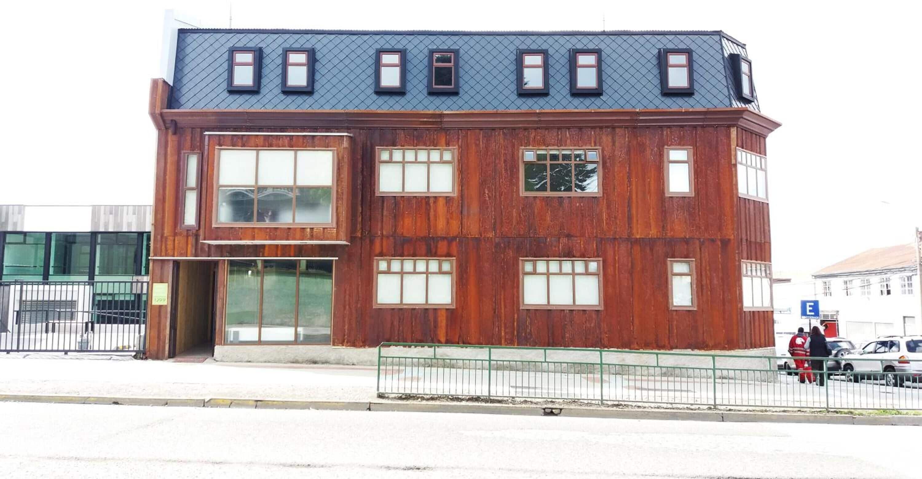 Een meerlaags gebouw met een houten gevel en grote ramen.