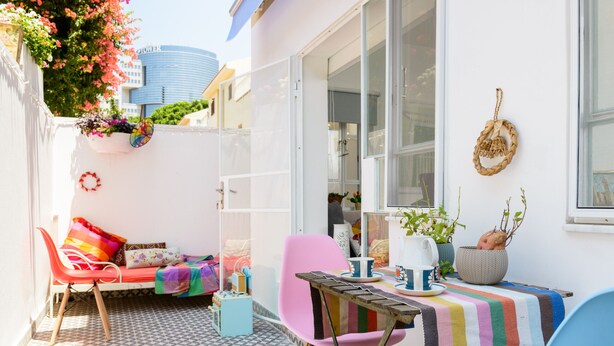 Une pièce confortable avec un lit, une table et des chaises, une fenêtre donnant sur un beau paysage et une plante suspendue.
