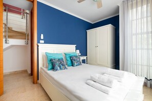 A bedroom with a bed, a wardrobe, a bedside table, and a ceiling fan. - MAMAD, Penthouse & Jacuzzi in Neve Tzedek by FeelHome (Tel Aviv - Jaffa)