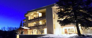 A modern multi-story building with balconies and a snow-covered ground, labeled "THE CHRISTOPHE".