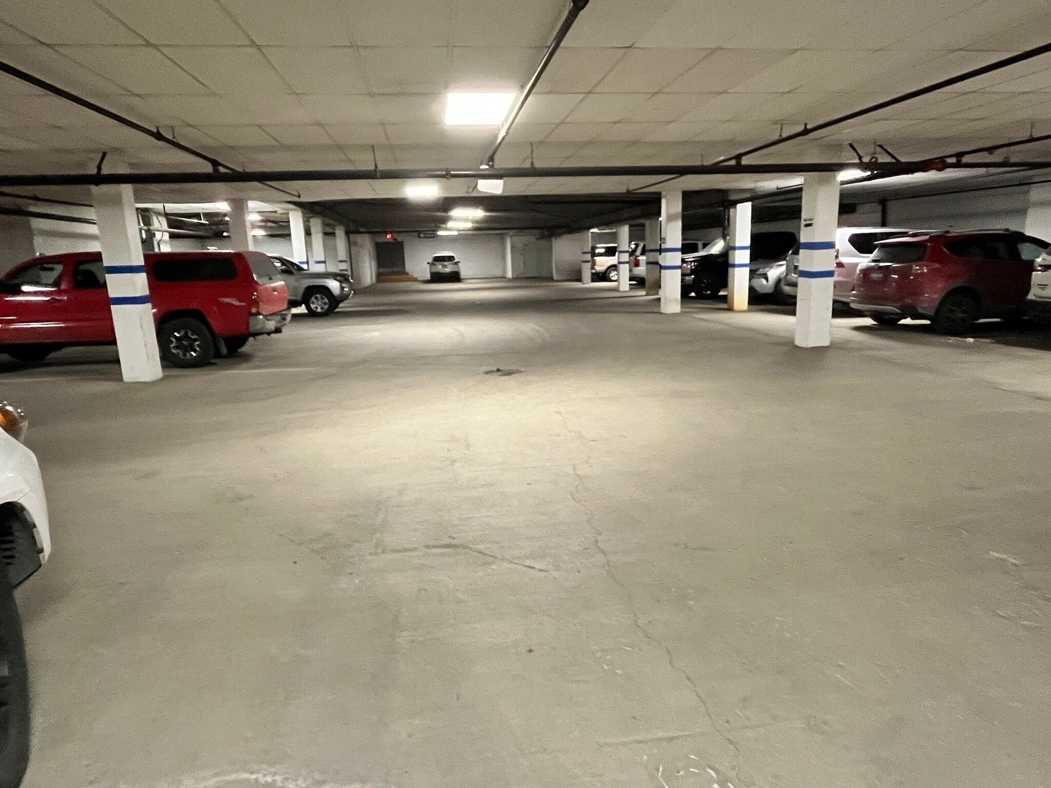 A multi-level parking garage with concrete floors and white pillars.