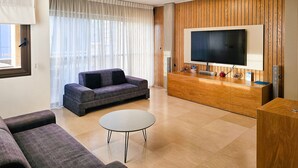 Un salon moderne avec un canapé, une table basse, un téléviseur et un mur recouvert de panneaux en bois.