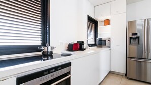 A modern kitchen with a built-in dishwasher, a stainless steel refrigerator, and a microwave.